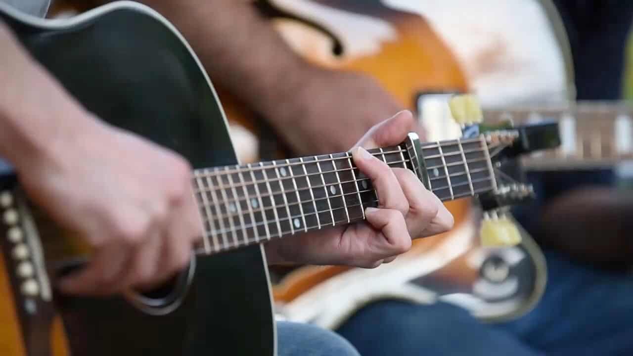 A group of people playing an acoustic guitar in Mayfair homes in New Braunfels.