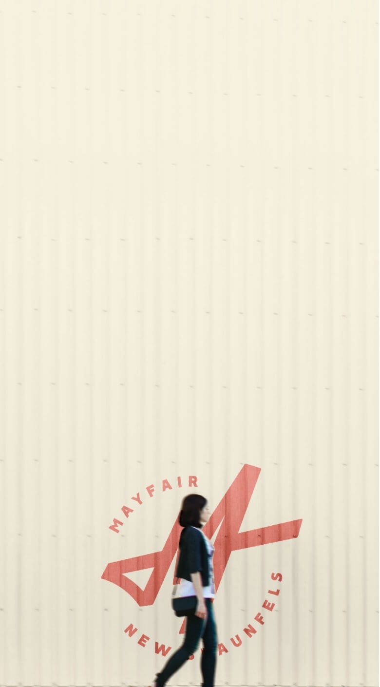 A woman walking past a building advertising new homes in New Braunfels, Texas.