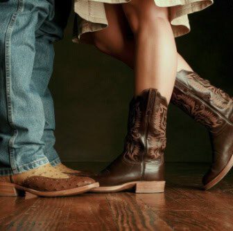 A couple in cowboy boots standing together.